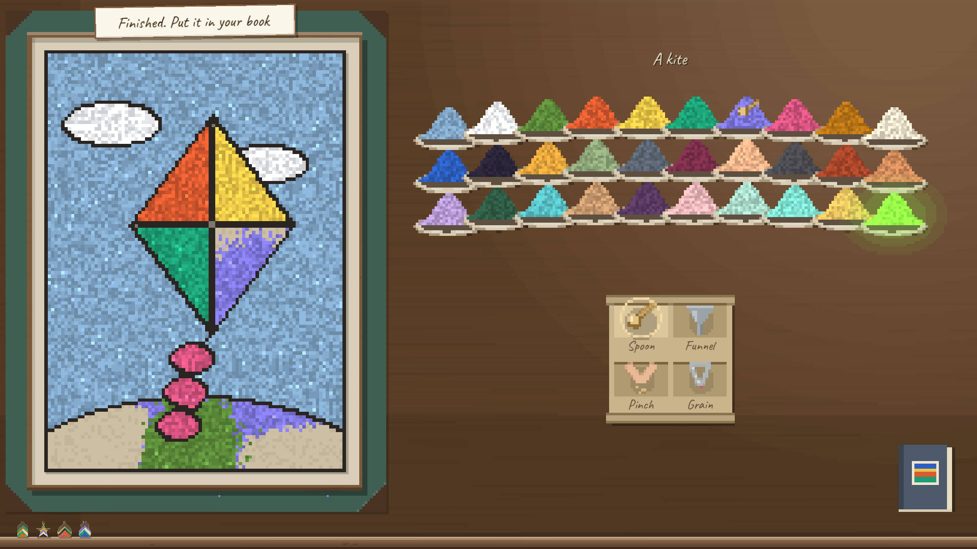 A finished sand board of a kite in four colors against a blue sky, its tail of pink bows, on the desk beside rows of sand.